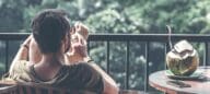 A young man relaxing on a balcony after solving his rent vs buy conundrum