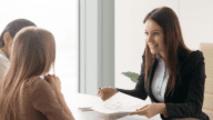 An agent explaining house buying companies to clients.